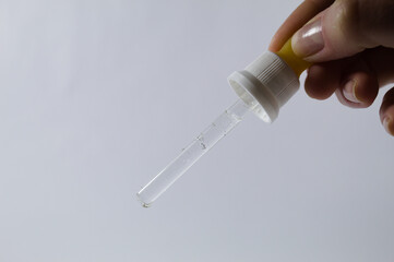 Dropper with glass ampoule with female hand holding