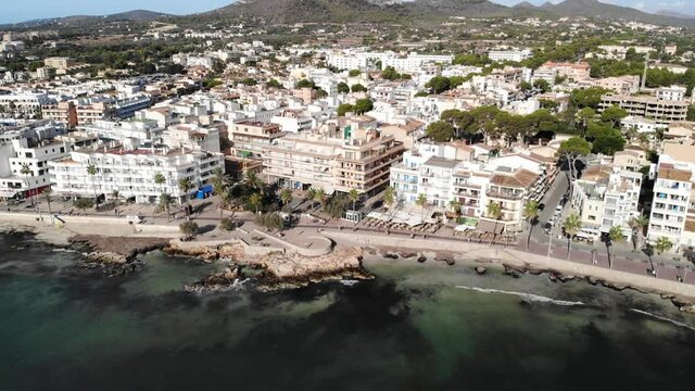 Aerial View of Cala Millor, Promenade, Coastal Buildings and Hotels on Mallorca Island, Baleares, Spain. Mediterranean Sea Coastline, Pull Back Drone Shot