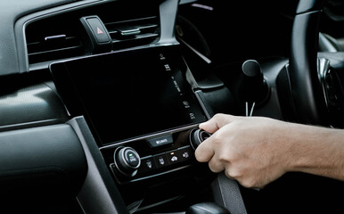 Man turning on car air conditioning system. Hand of man turning on car air conditioning system,Button on dashboard in car panel,Auto air conditioning.
