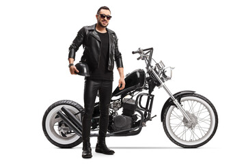 Full length portrait of a biker in leather jacket and pants with a chopper motorbike