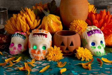 Sugar skulls used for "dia de los muertos" celebration in a grey background with cempasuchil flowers