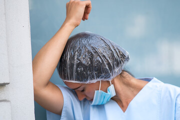 Tired, overworked, exhausted health care worker resting her head taking a break