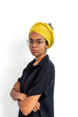 Close up of young mixed race woman with glasses and yellow scarf looking at camera while posing against white blank wall