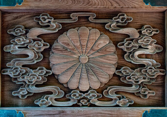 A chrysanthemum crest in the wooden door of the Japanese temple 