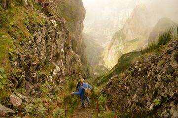Obraz premium Climbing to the dramatic peak of Pico Ruivo mountain on the ridge of Madeira Island, Portugal