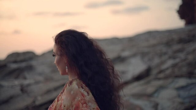 Bailarina de danza del vientre bailando en la playa al atardecer