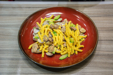 Homemade Passatelli (pasta made with Parmesan cheese, bread and eggs) with clams and zucchini served in Rimini, Italy