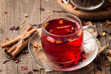 Cup of fresh red tea on wooden background