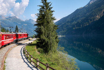 Obraz na płótnie Canvas Miralago, Switzerland - July 21, 2020 : View of Poschiavo lake and of the bernina train