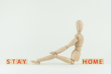 wooden mannequin and the inscription stay at home, the concept of self-isolation during the pandemic