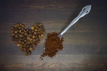Coffee beans and coffee powder in a spoon with wooden background. 
