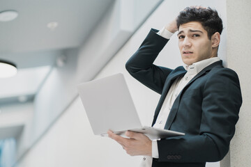 portrait of a young man of caucasian appearance looking at the camera. worried business man in a formal suit. Corresponding with a client about a meeting and discussion of a new strategy.