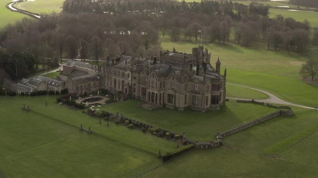 parallax drone shot of castle mansion on sunny day