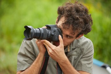 Photographer holdin a DSLR camera outdoors