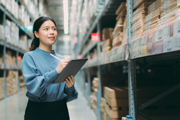 Young energetic smart Asian business working woman smile while using digital tablet to check goods...