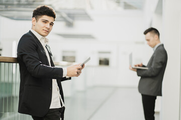 professional businessmen keep their distance in the office. men of young appearance works on gadgets. create new projects online an interesting idea. European appearance, stylish office