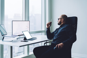 Busy trader working on gadgets in office
