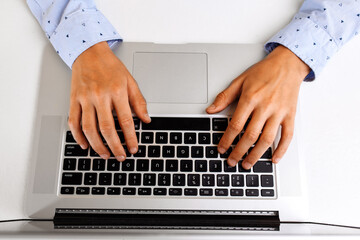 Fototapeta na wymiar Student hands typing on the laptop keyboard, doing homework