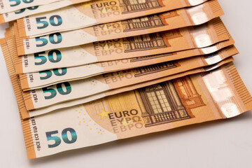 Cash banknotes 50 euros scattered on the white background, close up