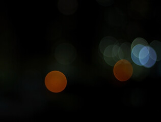 Dark background with bright colorful bokeh city lights.