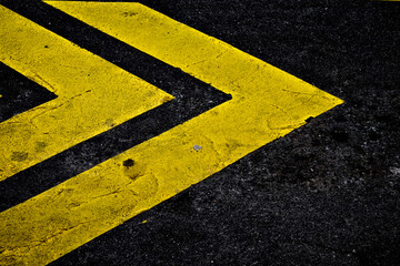 Bright yellow fluorescent markings on black tarmac pavement. - Powered by Adobe