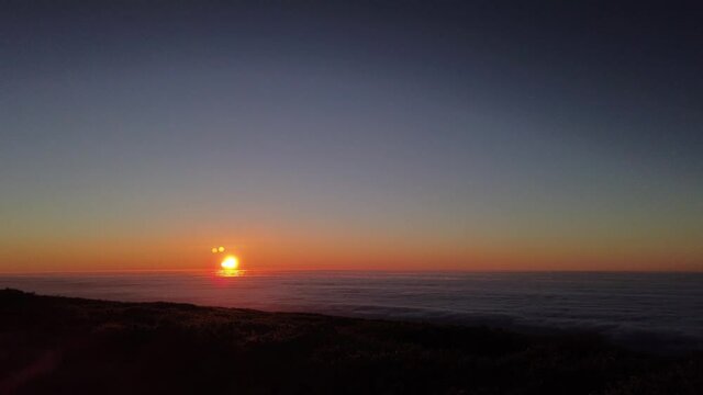 A time lapse of the sunset over a sea of clouds