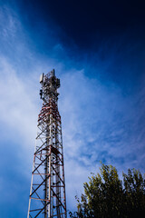 A tall modern communications tower provides telecommunications service to a city, negative space on...