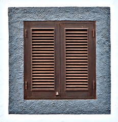 A simple closed window with brown louvered shutters, square and centered.
