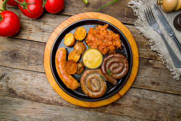 assorted sausages with sauces on old wooden table