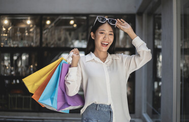 Asian woman sit rested after shopping in a colorful bag and she was happy to go shopping