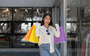 Asian woman sit rested after shopping in a colorful bag and she was happy to go shopping
