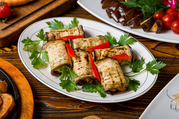 Eggplant rolls stuffed with nuts on white plate