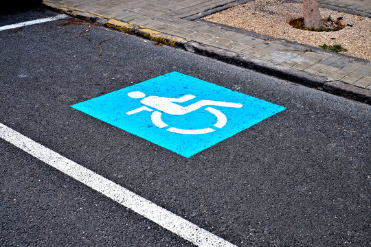 Blue wheelchair symbol marking a parking place reserved for drivers with physical disabilities.