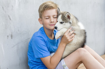 Dog owner petting and scratching his pet on a concrete background, a loving affectionate...