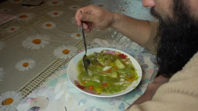A man eating homemade peruvian Minestrone soup