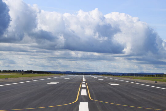 Empty runway at the Allg&auml;u Airport Memmingen with clouds above.