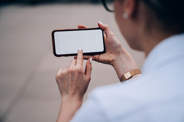 Crop woman using mobile phone