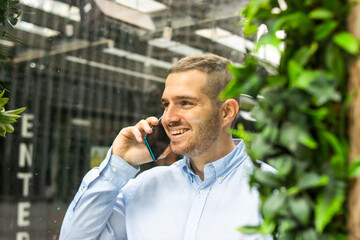 Photo of a young and attractive business man wearing smart casual and elegant clothes talking on...