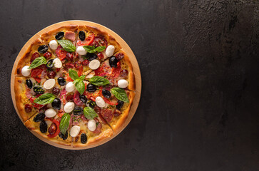 Whole pizza on black background with copy space