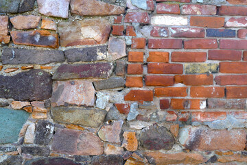 Old house wall of bricks, broken natural stones and old minerals, realistic texture background
