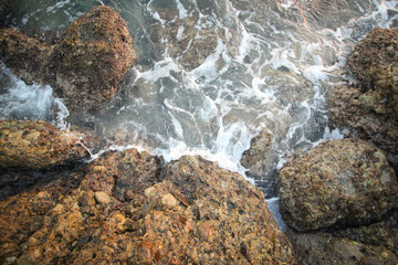 background of waves and rocks during the surf with sea foam