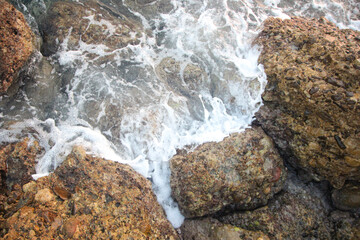 background of waves and rocks during the surf with sea foam
