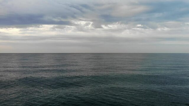 Vast open ocean out to the horizon locked off with overcast skies