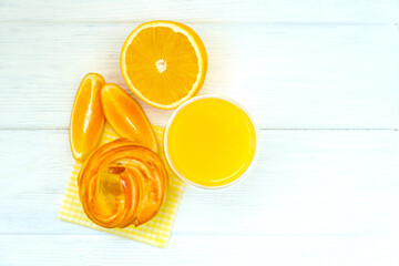 Naklejka premium Orange cake and orange juice on white wooden background