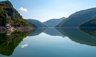 Beautiful mountain landscape with reflection, clear lake water with rocks and trees. Uvac lake in Serbia