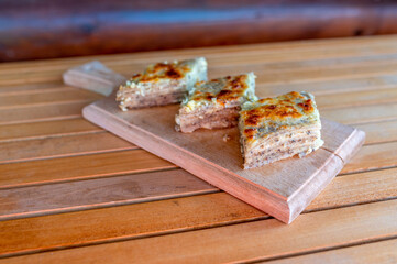 Delicious pieces of fresh baked homemade buckwheat pie filled with cheese on the wooden plate