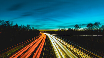 Fototapeta na wymiar Sunset/Twilight sky over long exposure 3 lane motorway