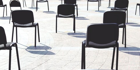 Chairs on the street are arranged in rows at a distance, keep your distance, quarantine measures, preparation for a conference, a concert