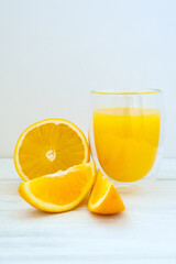 Oranges and orange juice on white wooden background