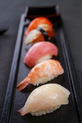 Nigiri sushi set on black plate, close up